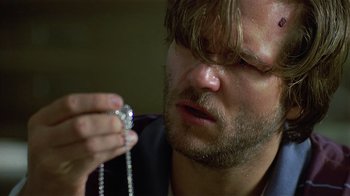 Movie still from “8 Million Ways to Die” (1986), directed by Hal Ashby – A person holding a necklace; Close Up shot, Over the shoulder angle