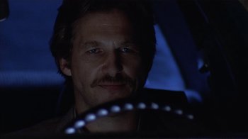 Movie still from “8 Million Ways to Die” (1986), directed by Hal Ashby – A person driving a car at night; Close Up shot, Low angle
