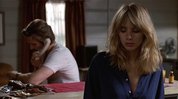 Movie still from “8 Million Ways to Die” (1986), directed by Hal Ashby – A woman sitting at a table in front of a man on the phone; Close Up shot, Over the shoulder angle