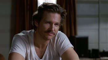 Movie still from “8 Million Ways to Die” (1986), directed by Hal Ashby – A person wearing a white t - shirt; Close Up shot, Over the shoulder angle