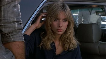 Movie still from “8 Million Ways to Die” (1986), directed by Hal Ashby – A woman sitting in the back of a car holding a cell phone to her ear; Close Up shot, Low angle