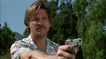 Movie still from “8 Million Ways to Die” (1986), directed by Hal Ashby – A man holding a gun while wearing a hawaiian shirt; Close Up shot, Low angle
