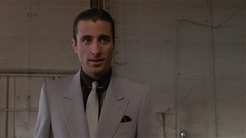 Movie still from “8 Million Ways to Die” (1986), directed by Hal Ashby – A person wearing a suit and a tie; Close Up shot, Low angle