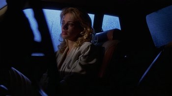 Movie still from “8 Million Ways to Die” (1986), directed by Hal Ashby – A woman sitting in the back seat of a car; Close Up shot, Low angle