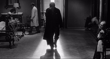 Movie still from “8½” (1963), directed by Federico Fellini – A man walking down the hall of a hospital; Wide shot, Low angle