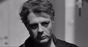 Movie still from “8½” (1963), directed by Federico Fellini – Black and white photograph of a man looking sad; Close Up shot, Low angle