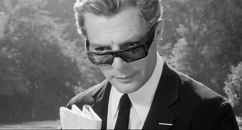 Movie still from “8½” (1963), directed by Federico Fellini – A black and white photo of a man in a suit holding a newspaper; Close Up shot, Low angle