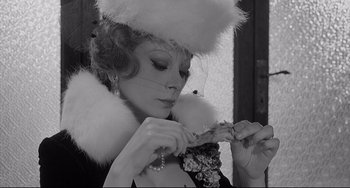 Movie still from “8½” (1963), directed by Federico Fellini – A woman wearing a fur hat and holding a veil; Close Up shot, Low angle