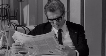 Movie still from “8½” (1963), directed by Federico Fellini – A black and white photo of a man reading a newspaper; Close Up shot, Over the shoulder angle