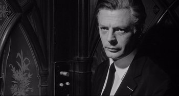Movie still from “8½” (1963), directed by Federico Fellini – Black and white photograph of a man wearing a suit and tie; Close Up shot, Low angle