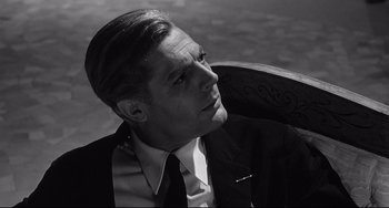 Movie still from “8½” (1963), directed by Federico Fellini – Black and white photograph of a man wearing a suit and tie; Close Up shot, Over the shoulder angle