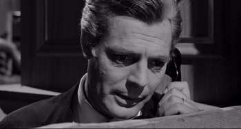 Movie still from “8½” (1963), directed by Federico Fellini – An older man talking on a phone while wearing a suit; Close Up shot, Low angle