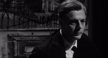 Movie still from “8½” (1963), directed by Federico Fellini – Black and white photograph of a man wearing a suit; Close Up shot, Low angle