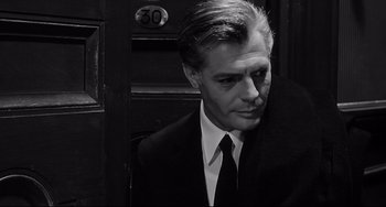 Movie still from “8½” (1963), directed by Federico Fellini – Black and white photograph of a man wearing a suit and tie; Close Up shot, High angle