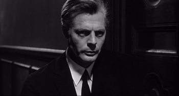Movie still from “8½” (1963), directed by Federico Fellini – Black and white photograph of a man in a suit; Close Up shot, Low angle