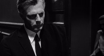 Movie still from “8½” (1963), directed by Federico Fellini – Black and white photograph of a man wearing a suit and tie; Close Up shot, Over the shoulder angle