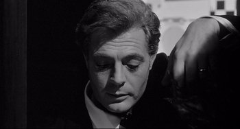 Movie still from “8½” (1963), directed by Federico Fellini – Black and white photograph of a man in a suit; Close Up shot, Low angle