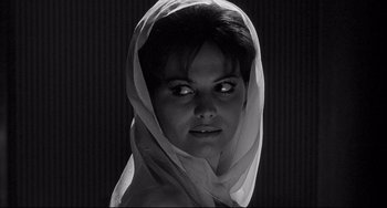 Movie still from “8½” (1963), directed by Federico Fellini – A black and white photo of a woman wearing a head scarf; Close Up shot, Low angle