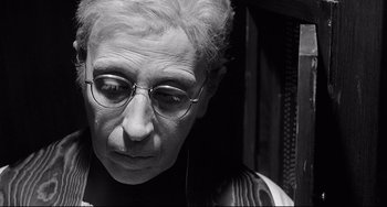 Movie still from “8½” (1963), directed by Federico Fellini – An older woman wearing glasses looking down at the ground; Close Up shot, High angle