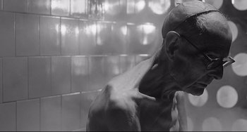 Movie still from “8½” (1963), directed by Federico Fellini – A black and white photo of a man in a shower; Close Up shot, High angle