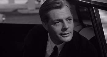 Movie still from “8½” (1963), directed by Federico Fellini – Black and white photograph of a man wearing a suit and tie; Close Up shot, Over the shoulder angle