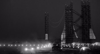 Movie still from “8½” (1963), directed by Federico Fellini – A black and white photo of a bridge with lights; Extreme Wide shot, Low angle