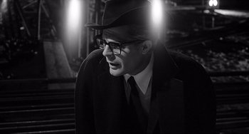 Movie still from “8½” (1963), directed by Federico Fellini – A man wearing a hat and a suit and tie; Close Up shot, Over the shoulder angle