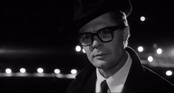 Movie still from “8½” (1963), directed by Federico Fellini – A man wearing a hat and glasses and wearing a coat; Close Up shot, Low angle