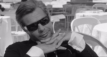 Movie still from “8½” (1963), directed by Federico Fellini – A black and white photo of a man wearing sunglasses; Close Up shot, Low angle