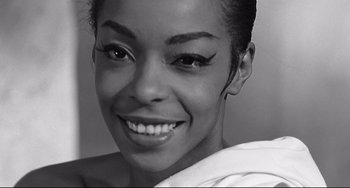 Movie still from “8½” (1963), directed by Federico Fellini – A black and white photo of a woman smiling for the camera; Close Up shot, Low angle