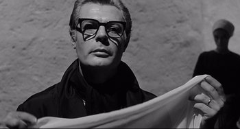 Movie still from “8½” (1963), directed by Federico Fellini – A black and white photo of a man wearing glasses; Close Up shot, Low angle
