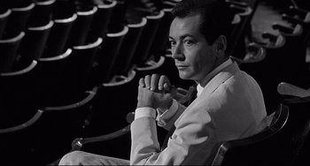 Movie still from “8½” (1963), directed by Federico Fellini – A black and white photo of a man sitting in a chair; Medium shot, High angle