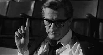 Movie still from “8½” (1963), directed by Federico Fellini – A black and white photo of a man in a suit and tie; Close Up shot, Low angle