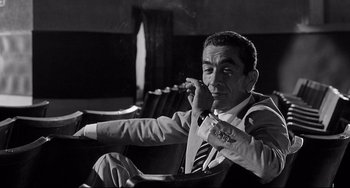 Movie still from “8½” (1963), directed by Federico Fellini – A black and white photo of a man smoking a cigarette; Medium shot, Low angle