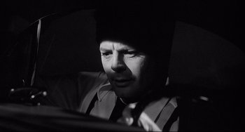 Movie still from “8½” (1963), directed by Federico Fellini – A black and white photo of a man looking at a computer screen; Close Up shot, Over the shoulder angle