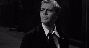 Movie still from “8½” (1963), directed by Federico Fellini – Black and white photograph of a man wearing a suit and tie; Close Up shot, Low angle