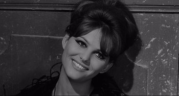 Movie still from “8½” (1963), directed by Federico Fellini – A black and white photo of a woman smiling for the camera; Close Up shot, High angle