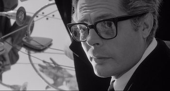 Movie still from “8½” (1963), directed by Federico Fellini – A black and white photo of a man wearing glasses; Close Up shot, Low angle