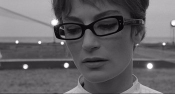 Movie still from “8½” (1963), directed by Federico Fellini – A person wearing glasses and a white shirt; Close Up shot, Low angle