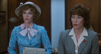 Movie still from “9 to 5” (1980), directed by Colin Higgins – Two women sitting next to each other in front of a wall; Close Up shot, Over the shoulder angle