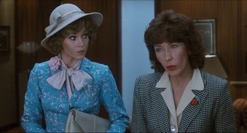Movie still from “9 to 5” (1980), directed by Colin Higgins – Two women are standing next to each other; Close Up shot, Over the shoulder angle