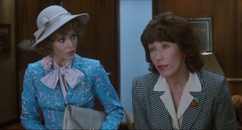 Movie still from “9 to 5” (1980), directed by Colin Higgins – Two women are sitting next to each other; Medium shot, Over the shoulder angle