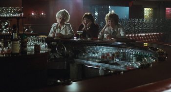 Movie still from “9 to 5” (1980), directed by Colin Higgins – A group of women sitting at a table in front of a bar; Wide shot, Over the shoulder angle