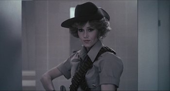 Movie still from “9 to 5” (1980), directed by Colin Higgins – A woman wearing a black hat and a tie; Close Up shot, Low angle