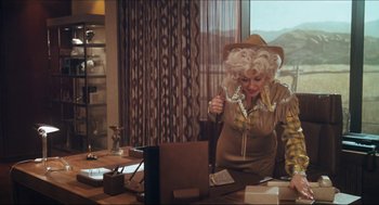 Movie still from “9 to 5” (1980), directed by Colin Higgins – A woman in a cowboy hat and a cowboy outfit; Medium shot, Low angle