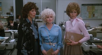 Movie still from “9 to 5” (1980), directed by Colin Higgins – A group of women standing next to each other in a room; Medium shot, Over the shoulder angle
