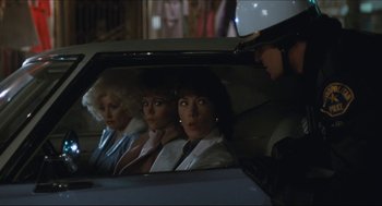 Movie still from “9 to 5” (1980), directed by Colin Higgins – A group of women sitting in the back seat of a car; Medium shot, Over the shoulder angle