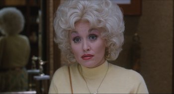 Movie still from “9 to 5” (1980), directed by Colin Higgins – A woman with blonde hair wearing a yellow sweater; Close Up shot, Over the shoulder angle