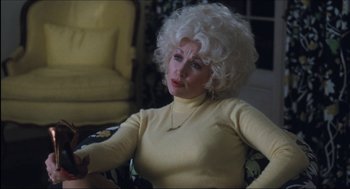 Movie still from “9 to 5” (1980), directed by Colin Higgins – An older woman with white hair sitting in a chair; Medium shot, Over the shoulder angle