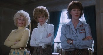 Movie still from “9 to 5” (1980), directed by Colin Higgins – A group of women standing next to each other in front of a window; Medium shot, Low angle